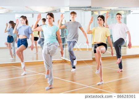 Teenagers in dance hall studying new movements Teenagers in dance hall studying new movements 86628301