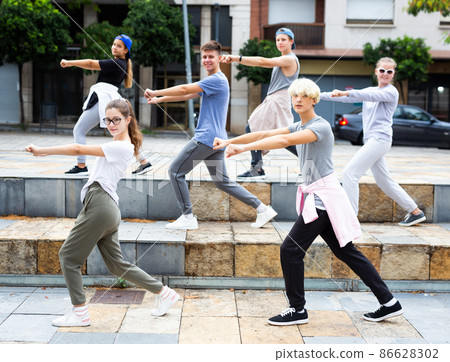 Group of dancing teenagers posing at street. Hip hop dancers Group of dancing teenagers posing at street. Hip hop dancers 86628302