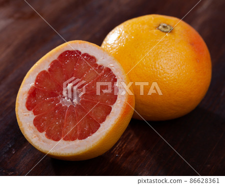 Whole and half fresh yellow pomelo on wooden table. Whole and half fresh yellow pomelo on wooden table. 86628361
