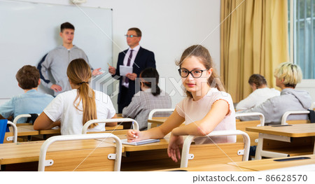 Teen girl sitting at desk in classroom 86628570