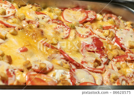 Baked cheesy meatballs casserole with tomato sauce in the oven dish. Baked cheesy meatballs casserole with tomato sauce in the oven dish. 86628575