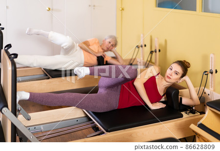 Active women perform a stretching exercise Active women perform a stretching exercise 86628809
