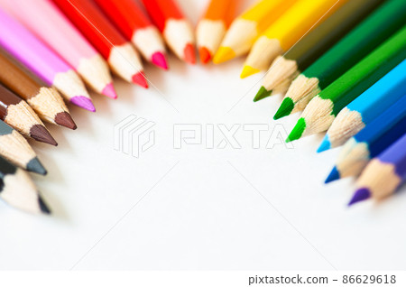 Set of wooden colored pencils on a white paper. Top view. 86629618