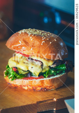 Double cheeseburger in the making. Fresh letucce leaf, beefm cheese and sauces. 86629628