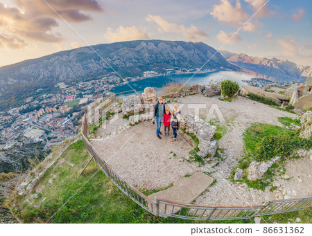 Family of hikers on Hiking in Kotor Old Town Ladder of Kotor Fortress Hiking Trail. Aerial drone view Family of hikers on Hiking in Kotor Old Town Ladder of Kotor Fortress Hiking Trail. Aerial drone view 86631362