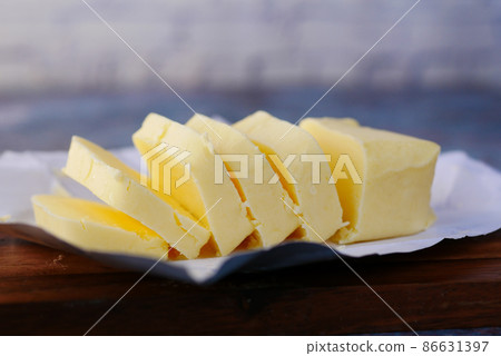 slice of a butter on a paper on table  86631397