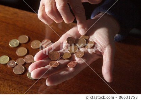 Wrinkled hands of elderly woman counting coins 86631758