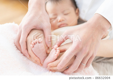 媽媽和爸爸的手撫摸著熟睡的嬰兒（新生兒）和腳 86632004