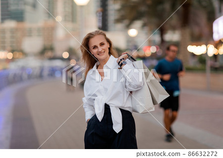 Portrait of an attractive woman with shopping in her hands Portrait of an attractive woman with shopping in her hands 86632272