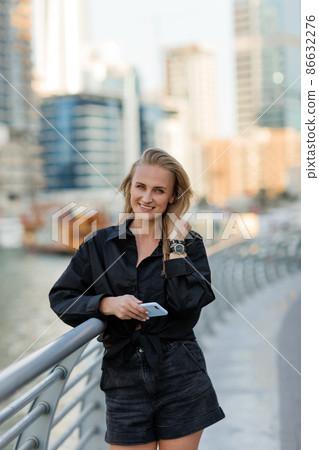 Portrait of a beautiful blonde woman while walking around the city. Copy space 86632276