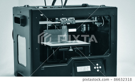 3D printer works and creates an object from the hot molten plastic 3D printer works and creates an object from the hot molten plastic 86632318