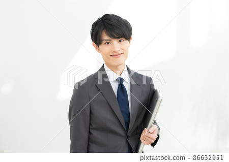 Portrait of a young businessman with a laptop on a white background 86632951