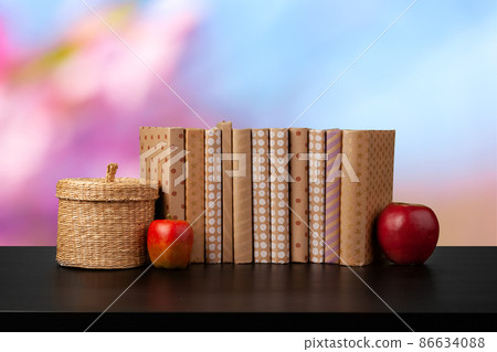 Stack of books on wooden table against blurred background Stack of books on wooden table against blurred background 86634088