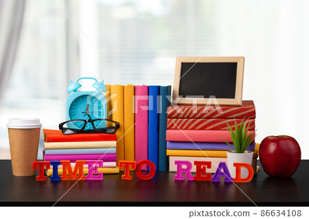 Stack of books on wooden table against blurred background Stack of books on wooden table against blurred background 86634108