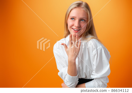 Portrait of smiling young teen girl against orange background Portrait of smiling young teen girl against orange background 86634112