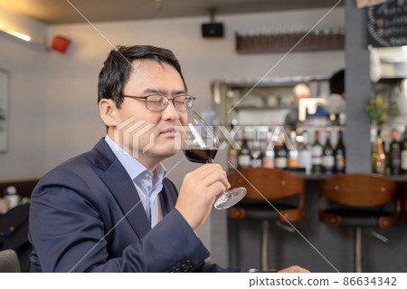 A man tasting wine at a restaurant 86634342