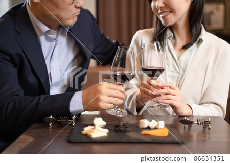 Men and women having a conversation drinking wine at a restaurant Men and women having a conversation drinking wine at a restaurant 86634351