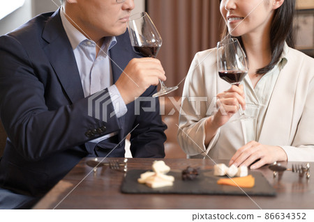 Men and women having a conversation drinking wine at a restaurant 86634352