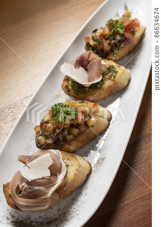 Pinchos tapas with jamon serrano and bruschetta on wood background Pinchos tapas with jamon serrano and bruschetta on wood background 86634674