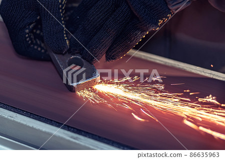 Closeup of Sparks that fly out when grinding metal details machine. Metallurgical Plant 86635963