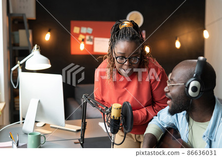 African young couple singing a song to the microphone together and playing guitar, they recording their song at home 86636031
