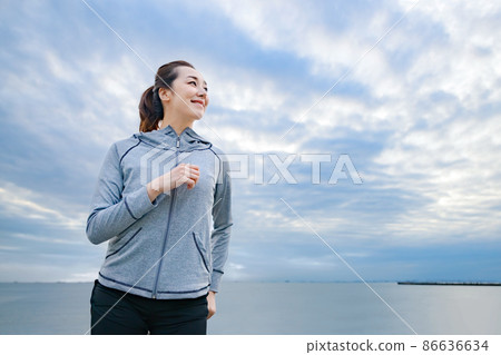 A woman in sportswear running by the sea A woman in sportswear running by the sea 86636634