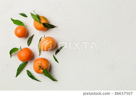 Many fresh ripe mandarin with green leaves on colored background, top view, space for text Many fresh ripe mandarin with green leaves on colored background, top view, space for text 86637507