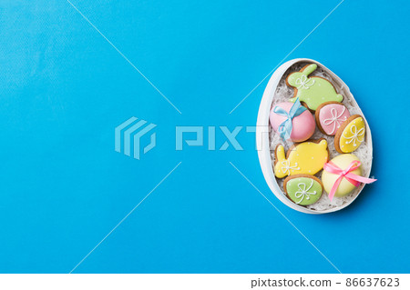 Colorful easter cookies in basket with Multi colors Easter eggs on colored background . Pastel color Easter eggs. holiday concept with copy space 86637623