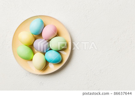 Multi colors Easter eggs in the woven basket on colored background . Pastel color Easter eggs. holiday concept with copy space Multi colors Easter eggs in the woven basket on colored background . Pastel color Easter eggs. holiday concept with copy space 86637644
