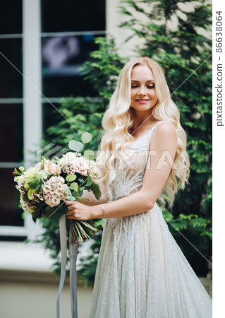 Elegant blondie bride smiling, holding wedding Elegant blondie bride smiling, holding wedding 86638064