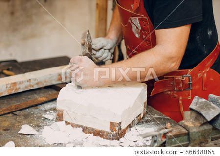 Man sculptor creates sculpt bust gypsum human woman sculpture with hammer. Statue craft creation workshop. Man sculptor creates sculpt bust gypsum human woman sculpture with hammer. Statue craft creation workshop. 86638065