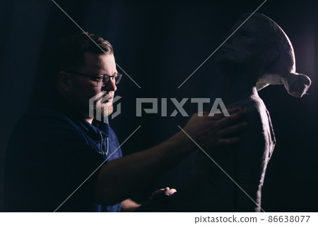 Man sculptor creates sculpt bust clay human woman sculpture. Statue craft creation workshop. Man sculptor creates sculpt bust clay human woman sculpture. Statue craft creation workshop. 86638077
