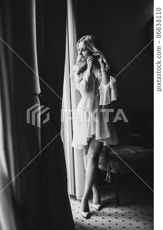 Gorgeous bride standing near balcony and looking Gorgeous bride standing near balcony and looking 86638110