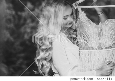 Gorgeous bride standing near balcony and looking Gorgeous bride standing near balcony and looking 86638114