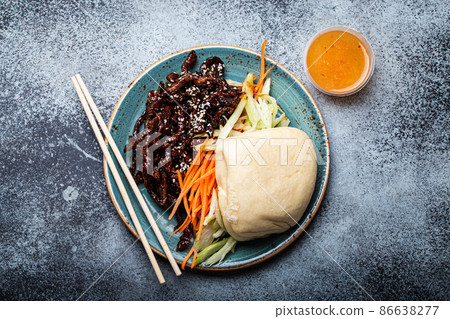 Chinese traditional dish sweet and sour deep fried glazed pork with vegetables and steamed bao bun 86638277