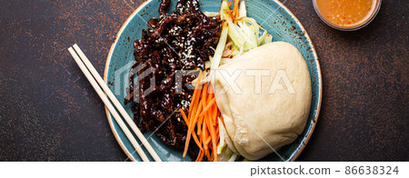 Chinese traditional dish sweet and sour deep fried glazed pork with vegetables and steamed bao bun 86638324