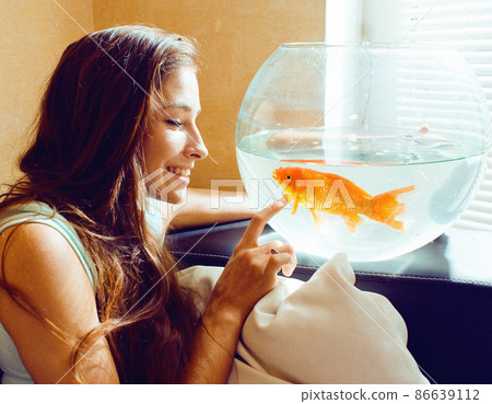 pretty woman playing with goldfish at home, sunlight morning pretty woman playing with goldfish at home, sunlight morning 86639112