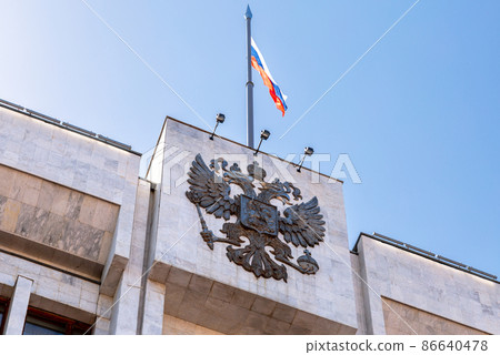 Russian coat of arms and the state flag on the building Russian coat of arms and the state flag on the building 86640478