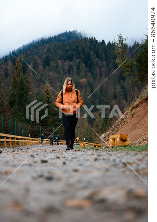 Walking on forest roads, a man walking alone on a forest road on the background of the mountain top with fog. Walking on forest roads, a man walking alone on a forest road on the background of the mountain top with fog. 86640924