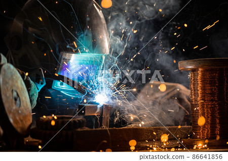 Welder welding a piece of iron tool Welder welding a piece of iron tool 86641856