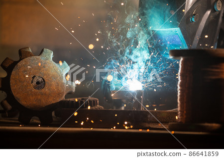 Welder welding a piece of iron tool Welder welding a piece of iron tool 86641859