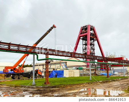 construction site. in the mine there is a metal, large, red underground crane. extraction of mining minerals. use of natural resources construction site. in the mine there is a metal, large, red underground crane. extraction of mining minerals. use of natural resources 86641913