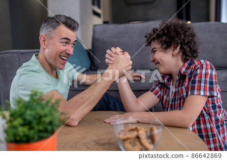 Man and boy wrestling with effort on hands 86642869