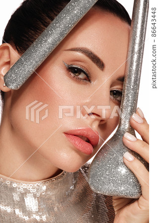 Beautiful woman with laboratory containers with silver liquid, make-up and hairstyle. Beauty face. Beautiful woman with laboratory containers with silver liquid, make-up and hairstyle. Beauty face. 86643448