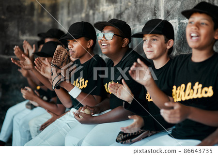 Their spirit is what keeps their team going. Cropped shot of a group of young baseball players cheering and supporting their team from the bench during a game. 86643735