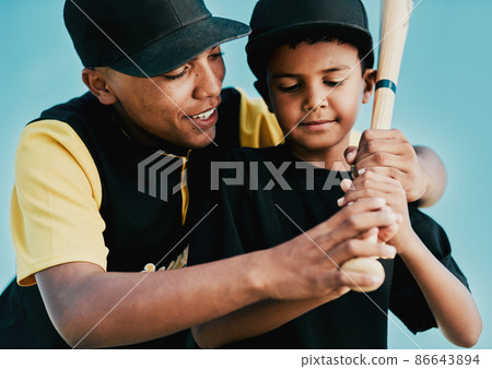 Im training him to be a great player. Shot of a young baseball player showing a little boy how to play. 86643894