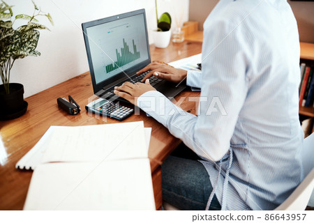 Working from home turned out to a profitable move. Cropped shot of a businesswoman using a laptop while analysing financial data at her desk. Working from home turned out to a profitable move. Cropped shot of a businesswoman using a laptop while analysing financial data at her desk. 86643957