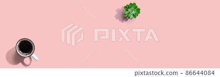 A cup of coffee and a small plant 86644084