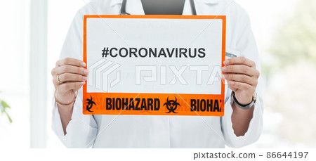 In on the fight against coronavirus. Shot of a medical practitioner holding up a sign with CORONAVIRUS on it. In on the fight against coronavirus. Shot of a medical practitioner holding up a sign with CORONAVIRUS on it. 86644197