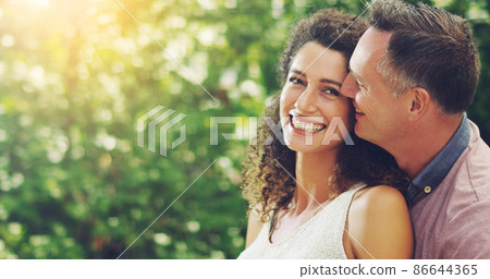 Hes the reason behind my smile. Shot of a happy and affectionate mature couple spending quality time together outdoors. 86644365